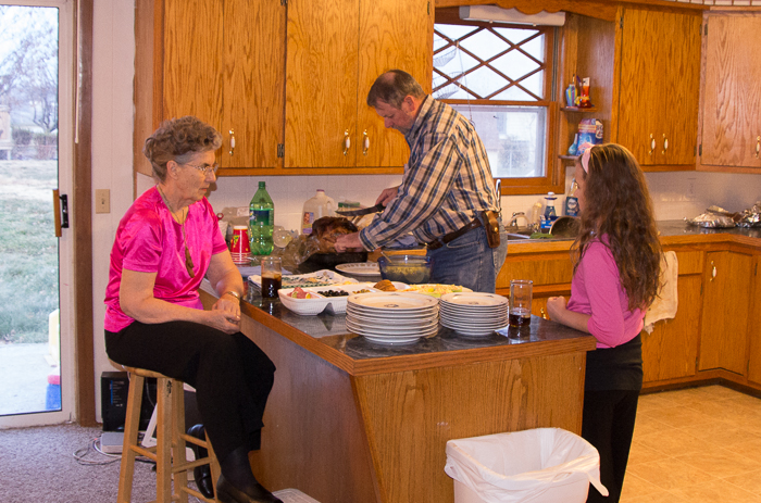 Richard cutting up the ham with Grandma and Delilah looking on.